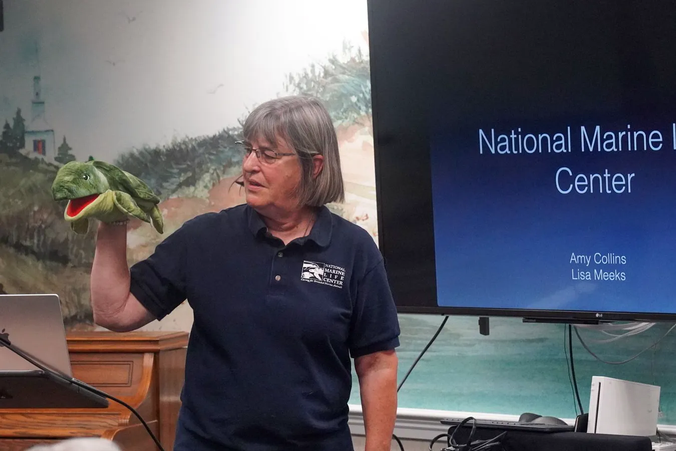 NMLC volunteer Lisa Meeks talking to audience about rehabilitation of Sea Turtles and the role NMLC plays